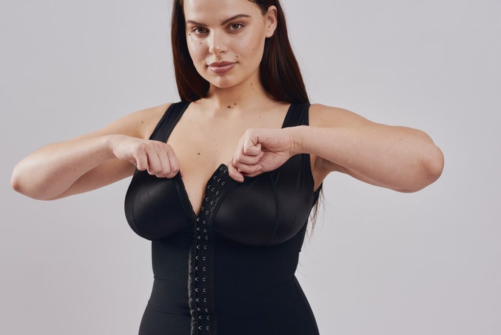 BodyAid black post-operative stage 1 bodysuit with built-in bra for extra support. Three row front hook and eye closure for multiple adjustments and control.