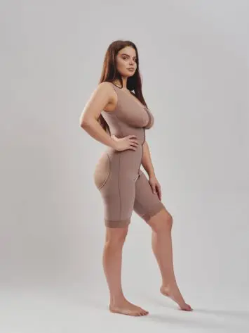 BodyAid natural post-operative comfort bodysuit with built-in bra for support. Three row front hook & eye closure for multiple adjustments & fit. Open crotch & non compressive butt lift shape support side view.