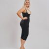 BodyAid Stage 1 Capri bodysuit in black with high back and adjustable straps. Features non brazilian butt lift shape support. BodyAid post surgery bra in beige. Side view.