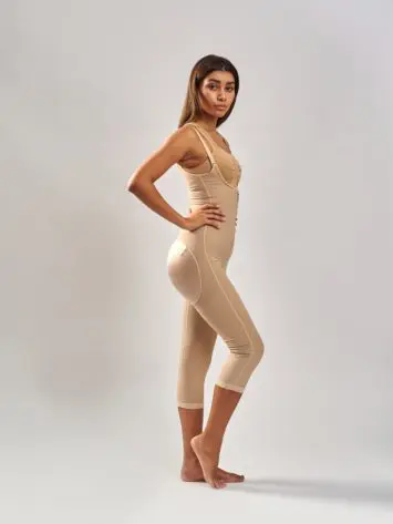 BodyAid Stage 1 Capri bodysuit in beige side view. Features non compressive butt lift shape support. BodyAid beige soft front fastening comfortable post op bra.