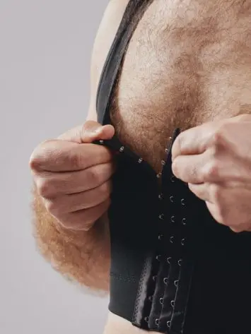 BodyAid chest compression binder in black. Features adjustable front hook and eye closure.