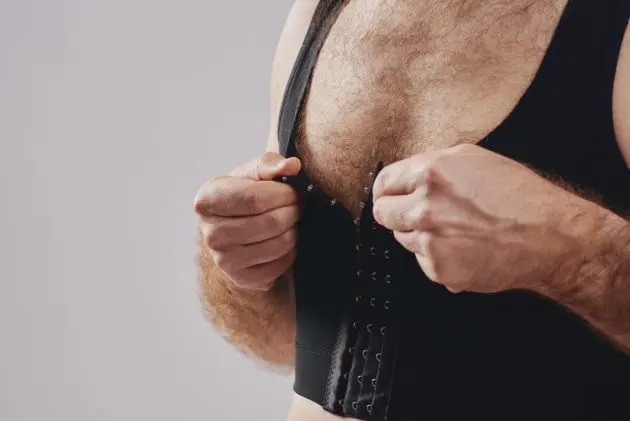 BodyAid chest compression binder in black. Features adjustable front hook and eye closure.
