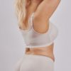 Leonisa posture bra with rear criss-cross support bands in beige. Front hook and eye closure and a smooth contouring finish. Instant Leonisa booty boosting padded beige panties. Rear view.